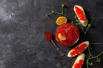 Red caviar on a dark background. Sandwiches with caviar