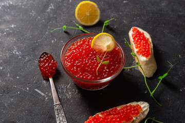 Red caviar on a dark background. Sandwiches with caviar