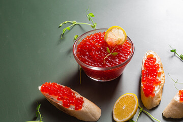 Red caviar on a dark background. Sandwiches with caviar