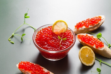 Red caviar on a dark background. Sandwiches with caviar