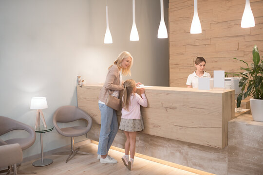 A blonde woman and her daughter waiting for the appointment at the clinic