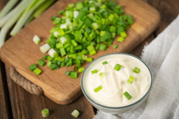 sour cream with sliced onion on wooden surface
