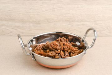 Slice beef with teriyaki sauce in small pan. Asian style food. Copy space.
