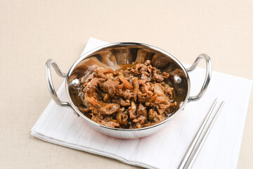 Slice beef with teriyaki sauce in small pan. Asian style food. Copy space.
