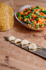 The process of cooking bulgur with vegetables. A dish of Middle Eastern cuisine is bulgur with carrots, string beans and mushrooms. The process of cooking vegetarian food. Bulgur with vegetable mix