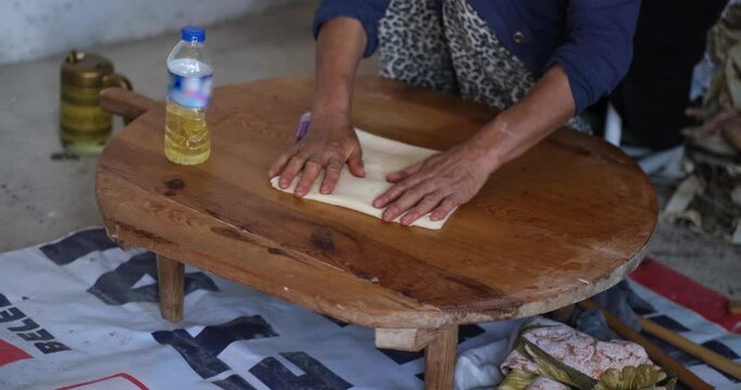 Baker hands kneading dough in flour on the table