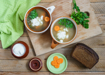 Pearl barley soup with forest mushrooms on a wooden rustic table