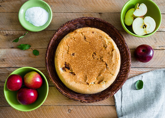 Homemade apple pie in a wicker plate on a wooden table