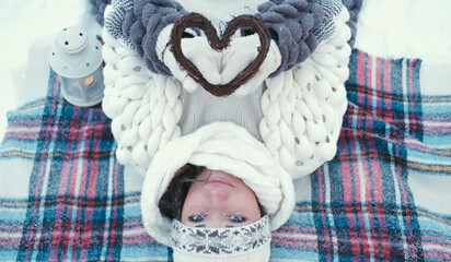 Portrait of a girl holding a handmade wooden Christmas decoration in the shape of a heart.