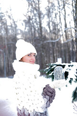 Portrait of a beautiful girl in a winter park, in her hands she holds a lantern with light bulbs.