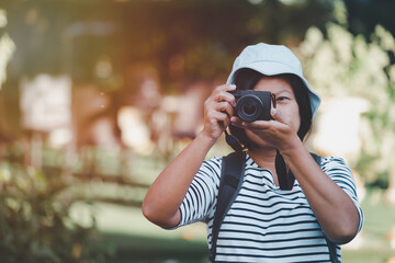 Portrait Asian woman tourists taking pictures with digital camera, Asian female photographer with holding professional digital camera vintage picture style, Travel concept.