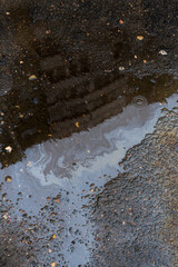 Beautiful abstract colorful background, stains of motor oil in a puddle with reflection of a building in blur.