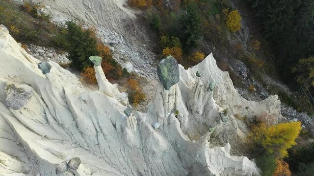 Aerial view on natural Earth Pyramids of Platten in autumn Dolomite Alps. Perca, Dolomites, Italy. UHD 4k drone video
