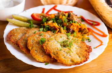 potato pancakes with grilled beef dish on a white plate