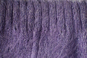 Knitted violet woolen sweater. Violet texture with cable pattern. Color 2022.