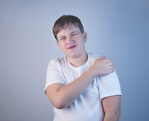 A young man suffering from shoulder pain. Concept disease. Pain in the shoulder joint, muscle pain....