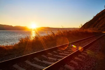 Selbstklebende Fototapeten Rot Lila Circum Baikal-Eisenbahn, die an einem sonnigen Herbsttag am Ufer des Baikalsees mit einer gelben Landschaft herum verläuft  © keleny