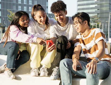 Group Of Happy Teenager Friends Using Their Mobile Phones App To Share Funny Moments