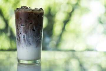 Naklejka na ściany i meble Iced coffee shows the texture milk and coffee in a glass cup
