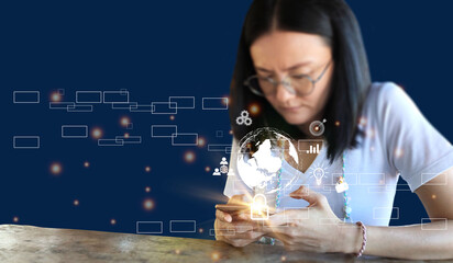 woman of Asian descent wearing spectacles looking down and messing with a cellphone.