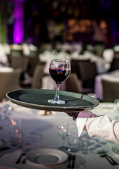 Waiter holding tray with red wine glass