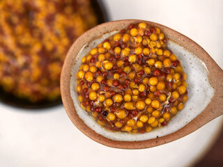 A spoonful of French mustard, close-up, top view, selective focus