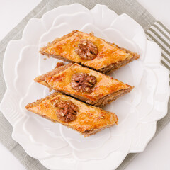 traditional oriental sweetness - baklava with walnuts on a white plate