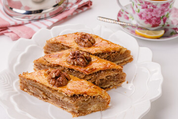 traditional oriental sweetness - baklava with walnuts on a white plate