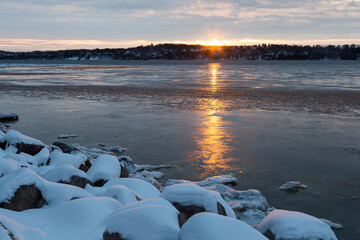 Blue hour sunrise view of the St. Lawrence River with a scattering of houses on the south shore...