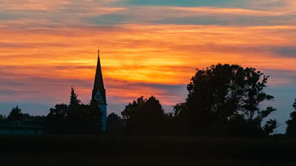 Beautiful sunset view with the silhouette of a church near Strasskirchen, Bavaria, Germany