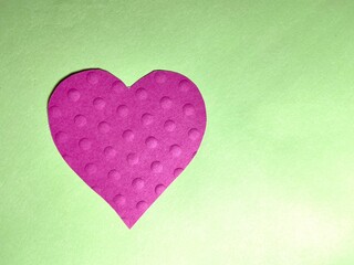 pink heart on green background  with texture dots on heart with copy space
