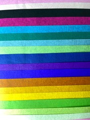 selection of tissue paper in various colours yellow, blue, green, pink background stripes