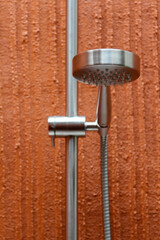 The modern shower head in orange bathroom of the hotel resort.