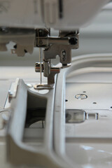 Closeup view of needle and foot of sewing machine.