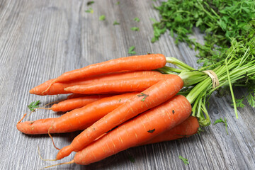 Organic fresh bunch of carrots on a wooden rustic table.