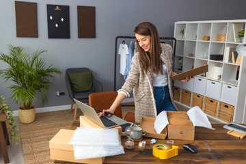 Young businesswoman working at her office. Young small business entrepreneur using smart phone at...