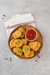 Golden chicken nuggets in a wooden plate, sprinkled with green onions and a lemon wedge. Pub menu. Flatlay