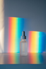 Face serum in front of rainbow