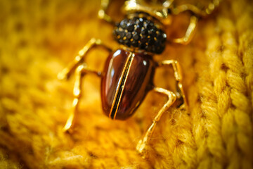 brooch jewelry Insect breaks on a yellow knitted sweater, an inexpensive jewelry jewelry in the entomological style