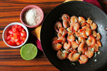 Brazilian food. Shrimp portion top view. Portion of shrimp with tomate, cassava flour and lemon
