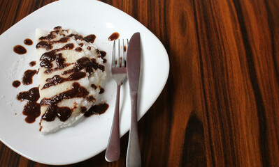 Sweet tapioca stuffed coconut grated with chocolate syrup. Brazilian food.