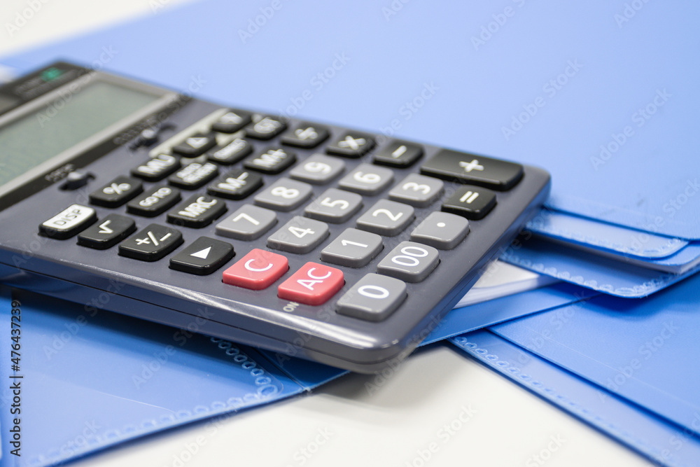 Poster calculator with file folder on table in work office, concepts business and cost and financial planni