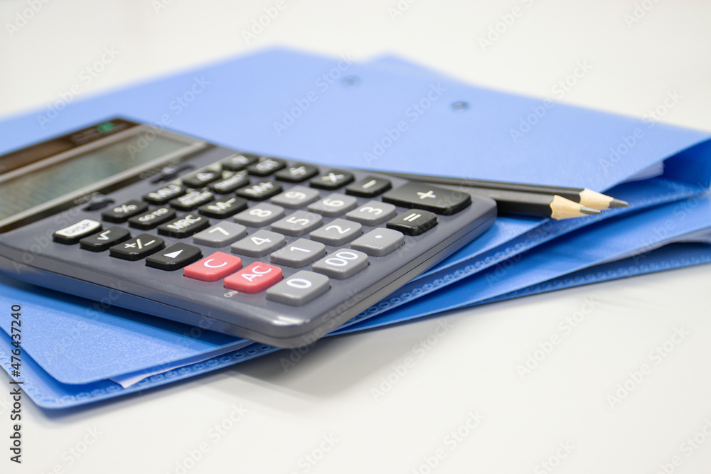 Poster calculator with file folder on table in work office, concepts business and cost and financial planni