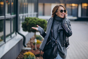 Fototapeta premium Young woman model in leather jacket outside the street