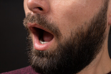 Obraz premium Close-up of open mouth of bearded young man feeling surprise, shock, excitement. Concept of expressions of emotions and feelings.