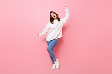 Full length photo of joyful happy young woman dance funky good mood isolated on pastel pink color background