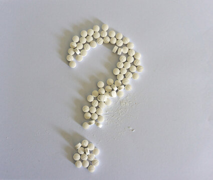 Pills in the form of a question mark. Isolated image on a white background.