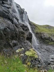Fototapeta na wymiar Stunning waterfalls with white streams coming down over black lava rocks on the Faroe Islands 