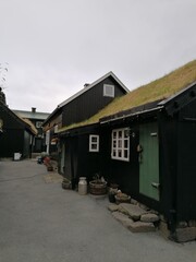 Traditional old cute stone houses with grass roofs on the Faroe Islands with a mountain view