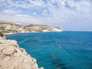 A rocky Aphrodite's beach in Petra tou Romiou, Cyprus. Beach stretches far away, surrounded by...